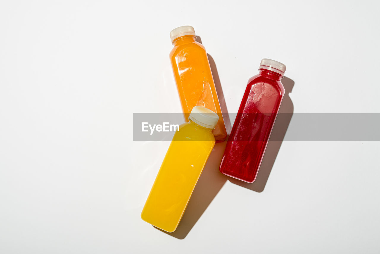 studio shot, healthcare and medicine, container, medicine, white background, bottle, indoors, yellow, orange, pill, capsule, no people, still life, dose, food, cut out, food and drink, group of objects