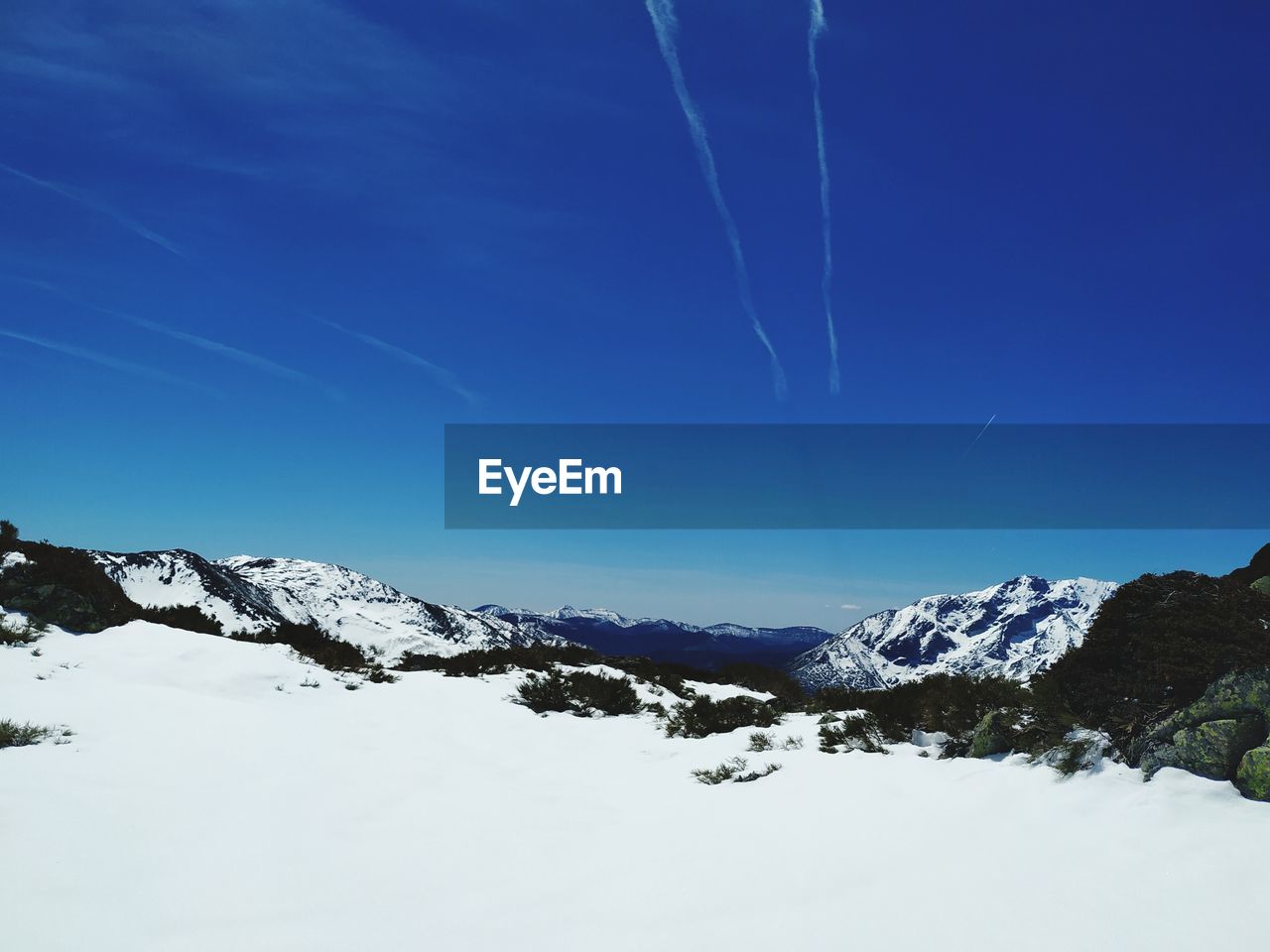 SNOW COVERED MOUNTAINS AGAINST BLUE SKY