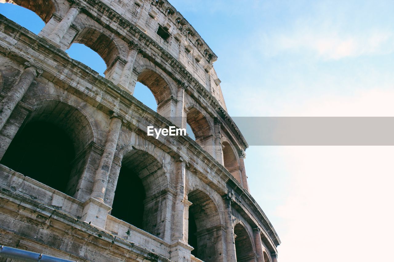 Low angle view of colosseum against sky in city