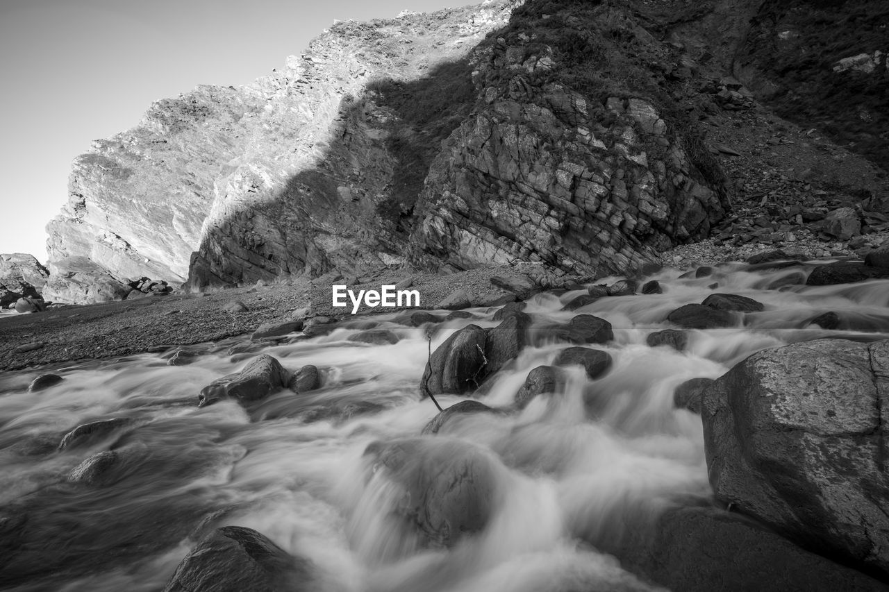 rock, scenics - nature, water, beauty in nature, nature, environment, black and white, motion, monochrome photography, monochrome, land, mountain, long exposure, waterfall, landscape, coast, no people, sea, sky, rapid, wave, outdoors, non-urban scene, travel destinations, rock formation, travel, tranquility, tranquil scene, flowing, idyllic, blurred motion, flowing water, wilderness, day, cold temperature, sports, snow, mountain range
