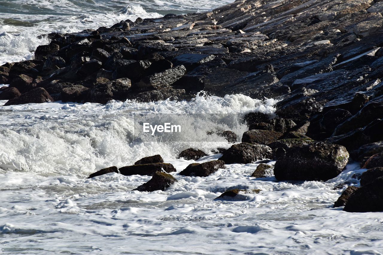 Strong wind generated waves on adriatic coast. rocky coastline is hit by waves crushing on land