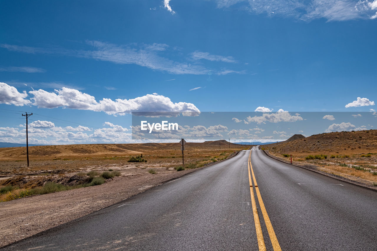 Road passing through landscape against sky