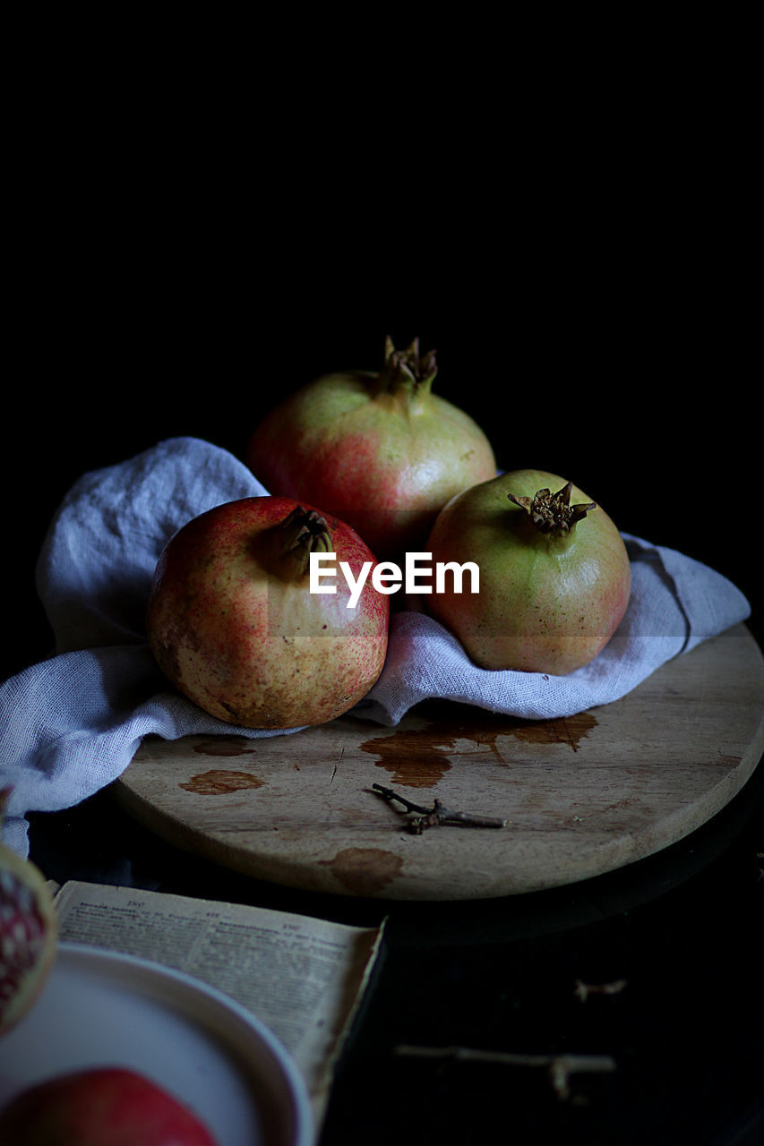 Close-up of pomegranates on table against black background
