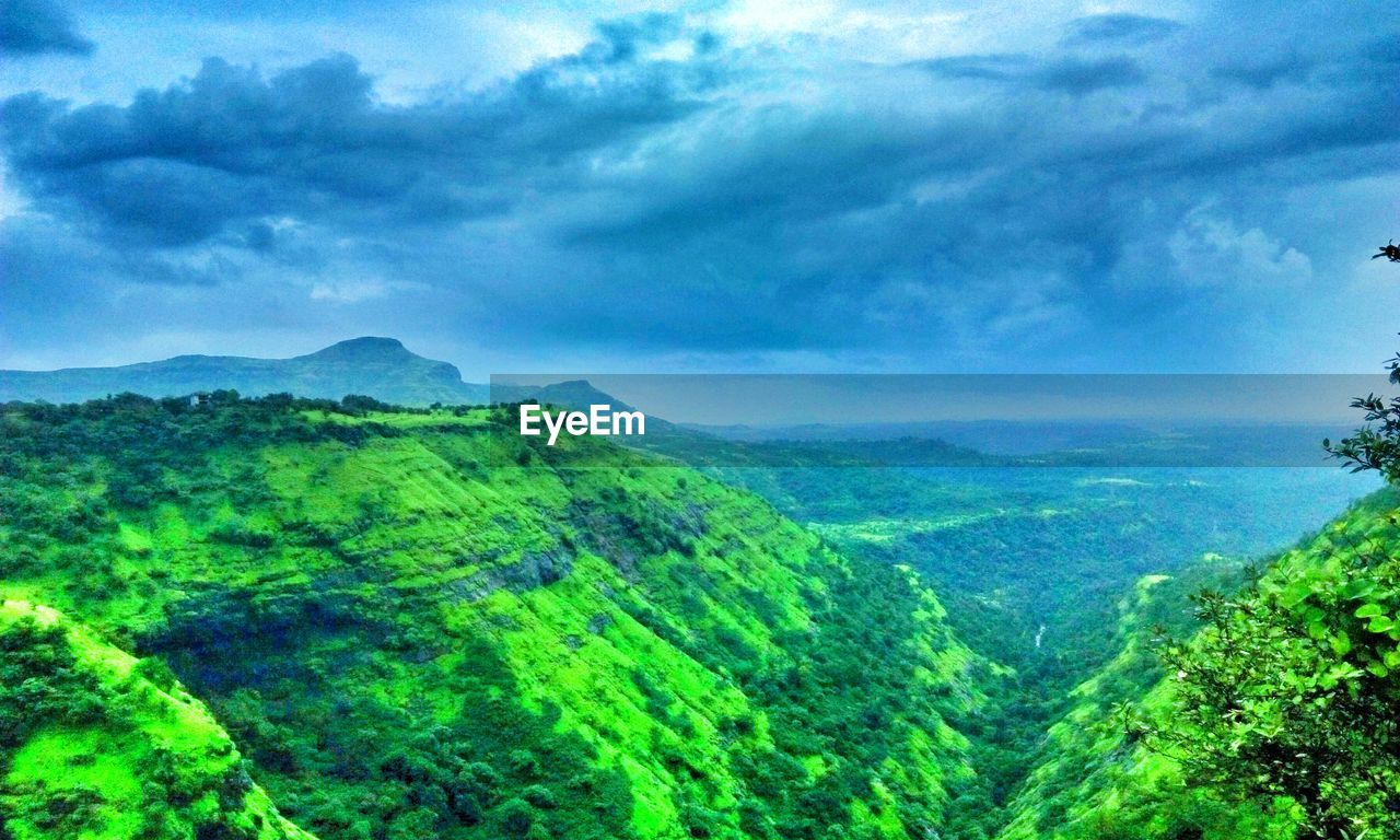 SCENIC VIEW OF GREEN LANDSCAPE AGAINST BLUE SKY