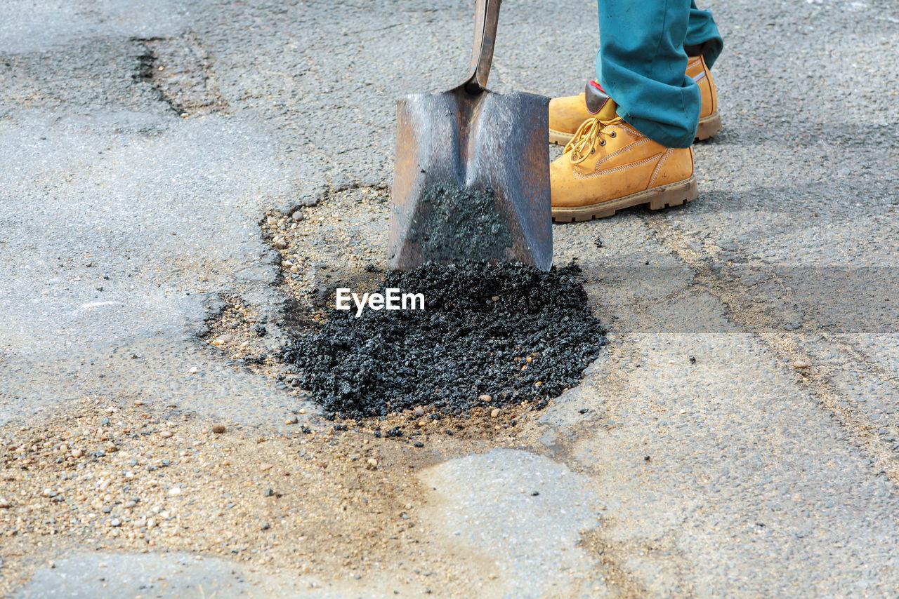 Low section of worker repairing road