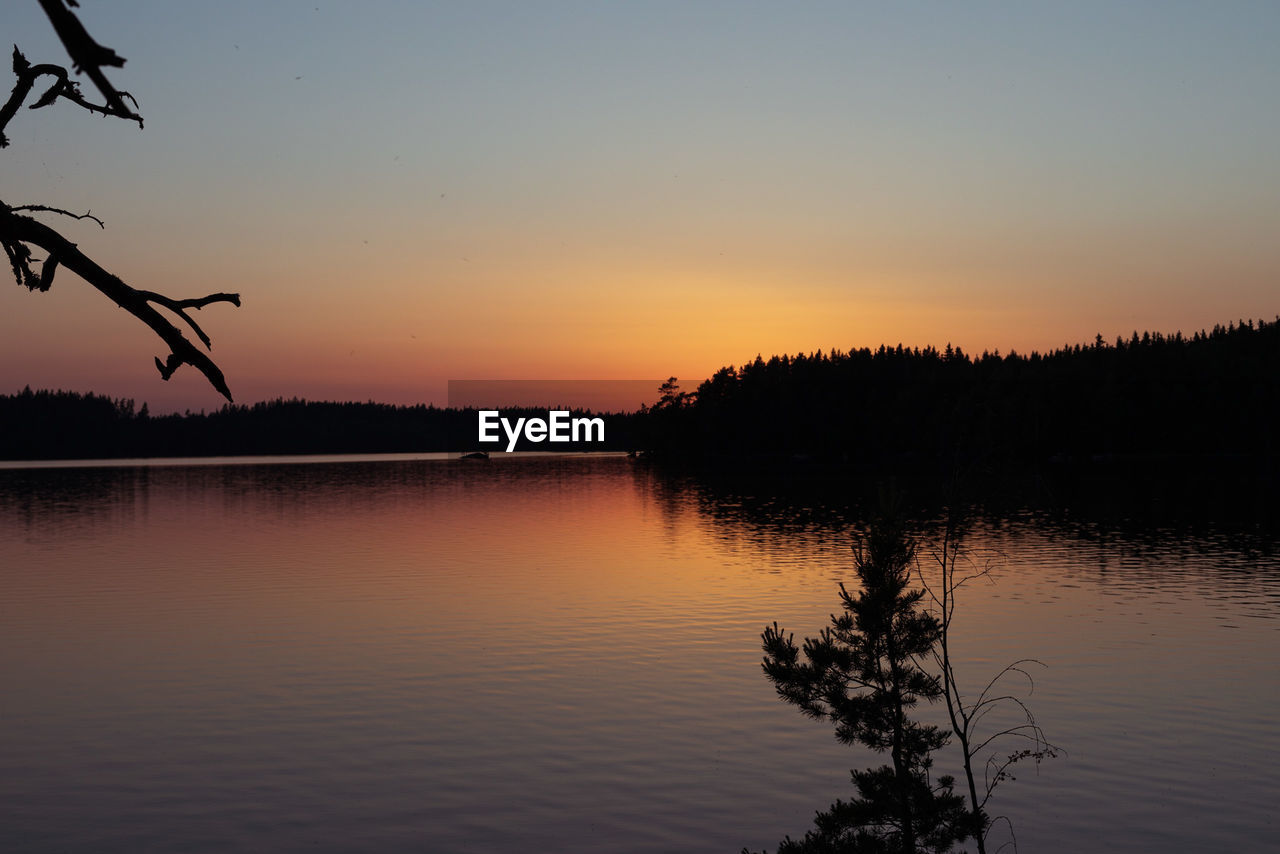 SCENIC VIEW OF LAKE AT SUNSET