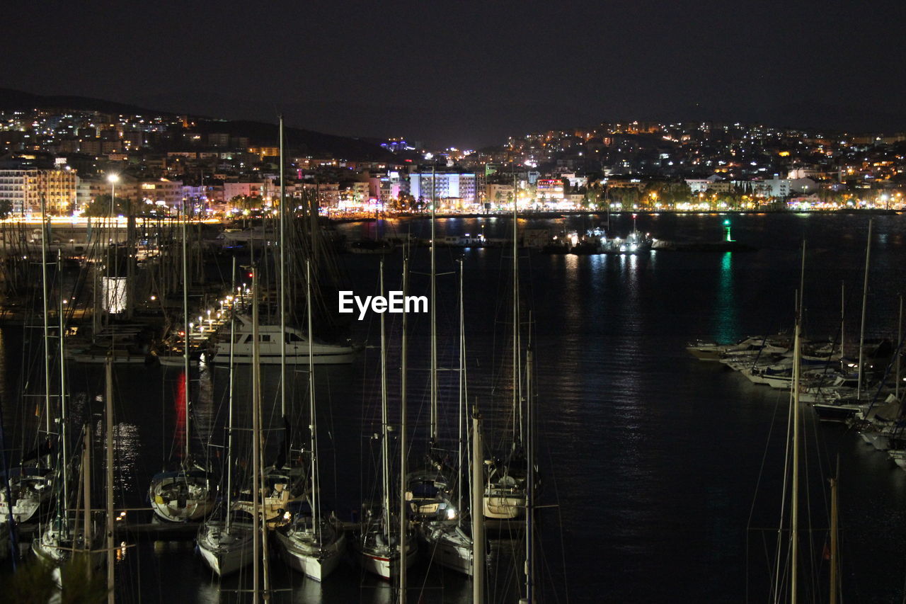 High angle view of illuminated harbor against buildings at night