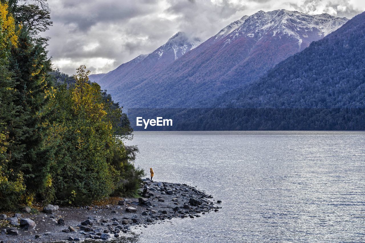 Scenic nature view of lake and mountain against cloudy sky