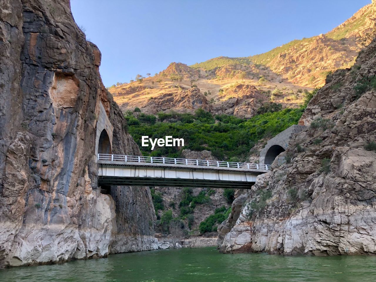 Arch bridge over mountain against sky