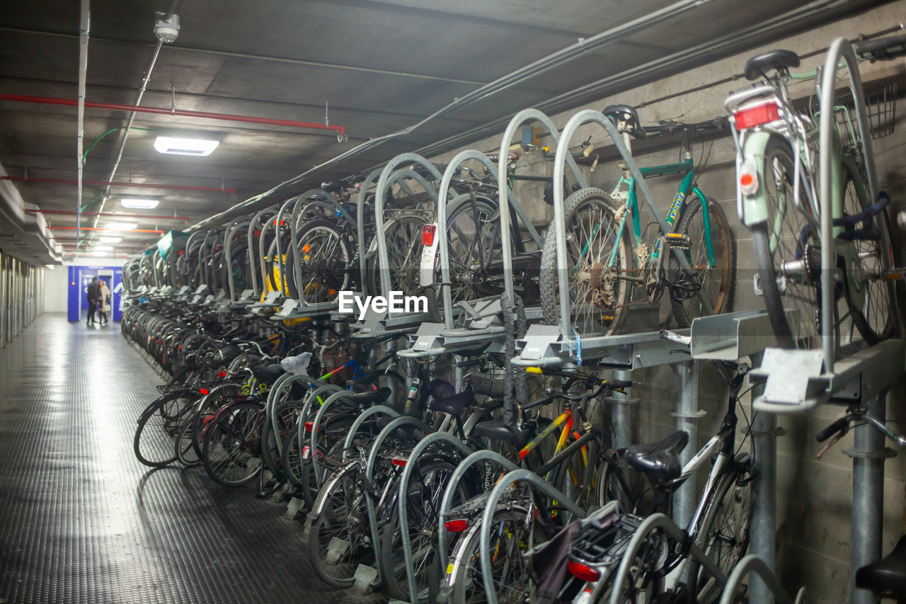 transportation, bicycle, mode of transportation, indoors, vehicle, transport, in a row, cycling, sport venue, large group of objects, architecture, no people, business, abundance, business finance and industry, land vehicle, bicycle shop