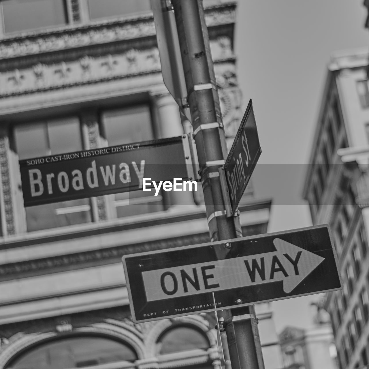 LOW ANGLE VIEW OF ROAD SIGN AGAINST CITY