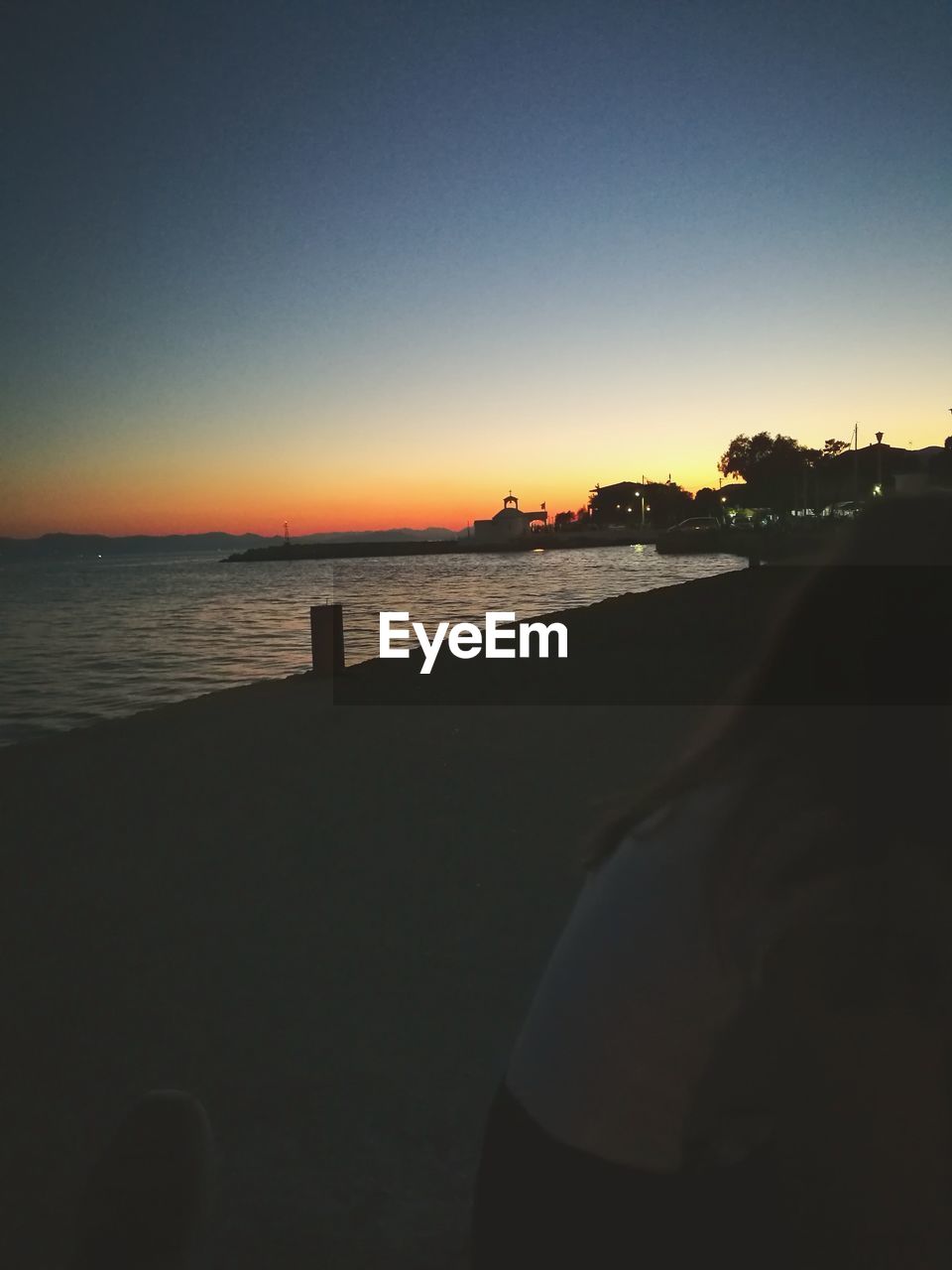 SCENIC VIEW OF BEACH AGAINST CLEAR SKY DURING SUNSET