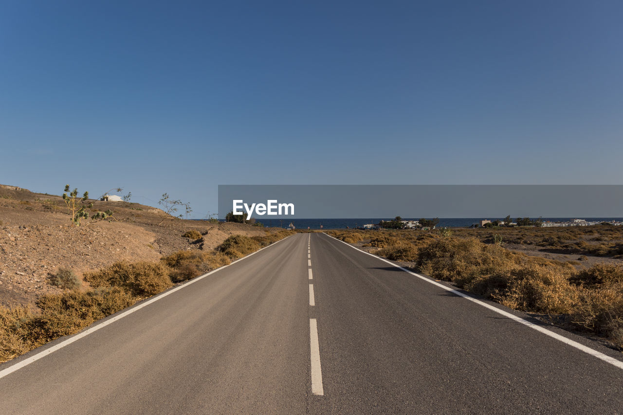 Empty road towards the sea in fuerteventura, canary islands
