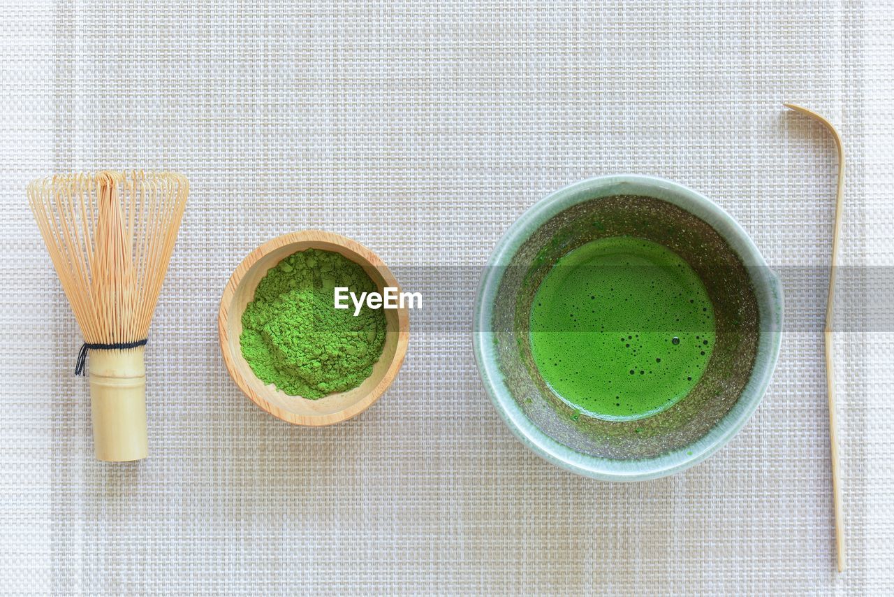 HIGH ANGLE VIEW OF GREEN TEA CUPS ON TABLE