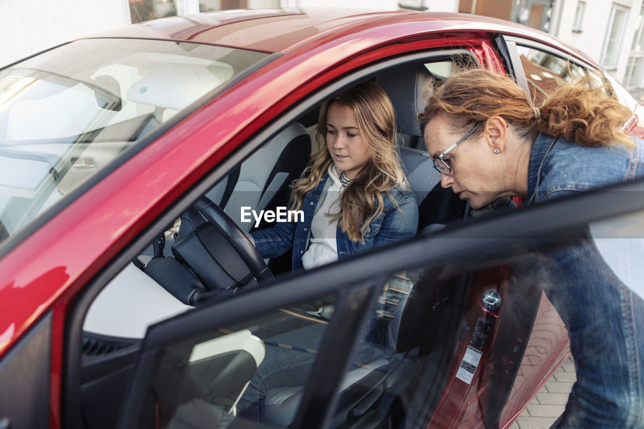 Mother teaching daughter driving during vacations