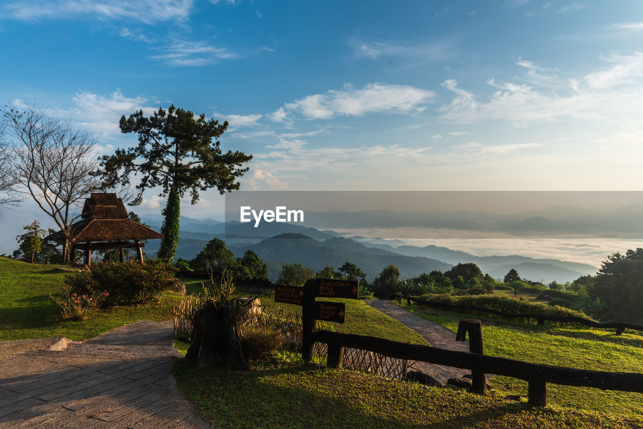 sky, nature, landscape, environment, architecture, cloud, hill, plant, scenics - nature, rural area, morning, tree, rural scene, beauty in nature, land, building, built structure, travel destinations, field, travel, house, tranquility, no people, grass, tourism, outdoors, sunlight, building exterior, blue, sun, religion, agriculture, tranquil scene, footpath, summer, twilight, horizon, sunrise, residential district, wood, mountain range, non-urban scene, vacation, idyllic, trip, farm