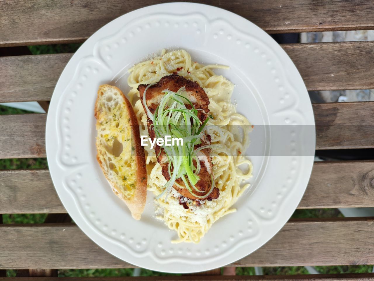 food and drink, food, wood, freshness, spaghetti, healthy eating, plate, italian food, pasta, wellbeing, dish, table, high angle view, no people, cuisine, vegetable, produce, directly above, fast food, meal, indoors, still life, garnish, carbonara, cheese, fork, serving size