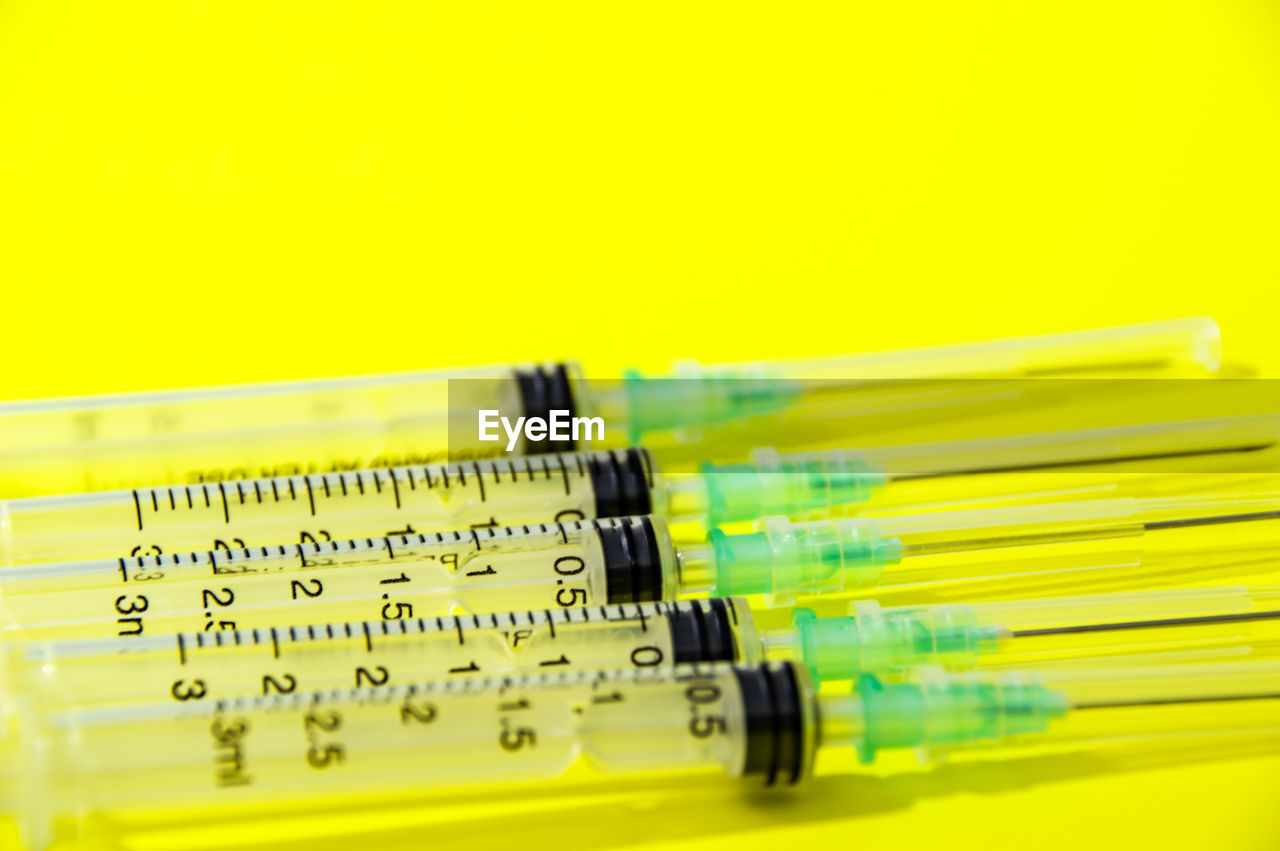 yellow, indoors, healthcare and medicine, studio shot, no people, close-up, science, colored background, research, syringe, education