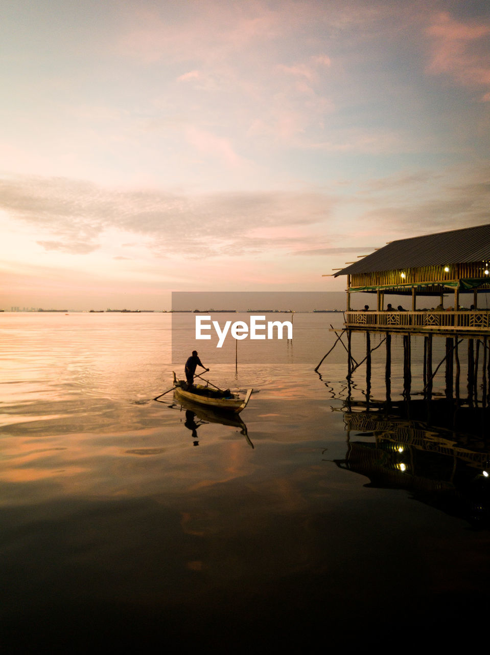 SILHOUETTE MAN ON BOAT IN SEA AGAINST SKY