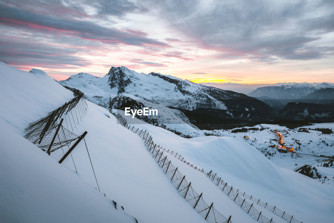 Scenic view of snow covered mountains against sky during sunset