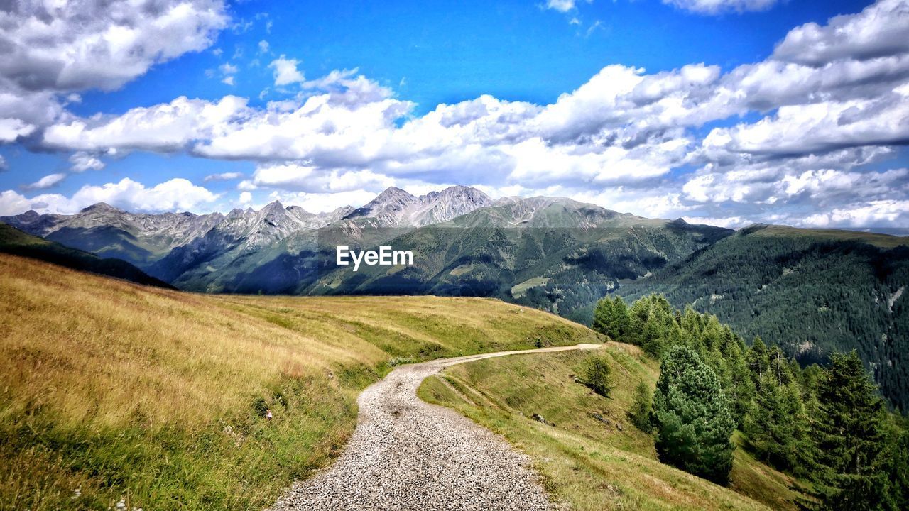 SCENIC VIEW OF ROAD AMIDST MOUNTAINS AGAINST SKY