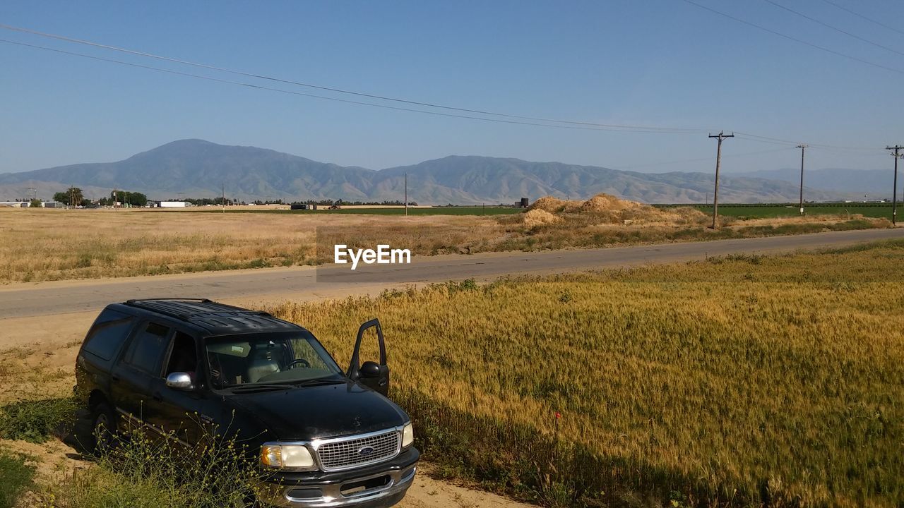 CAR ON MOUNTAIN ROAD AGAINST SKY