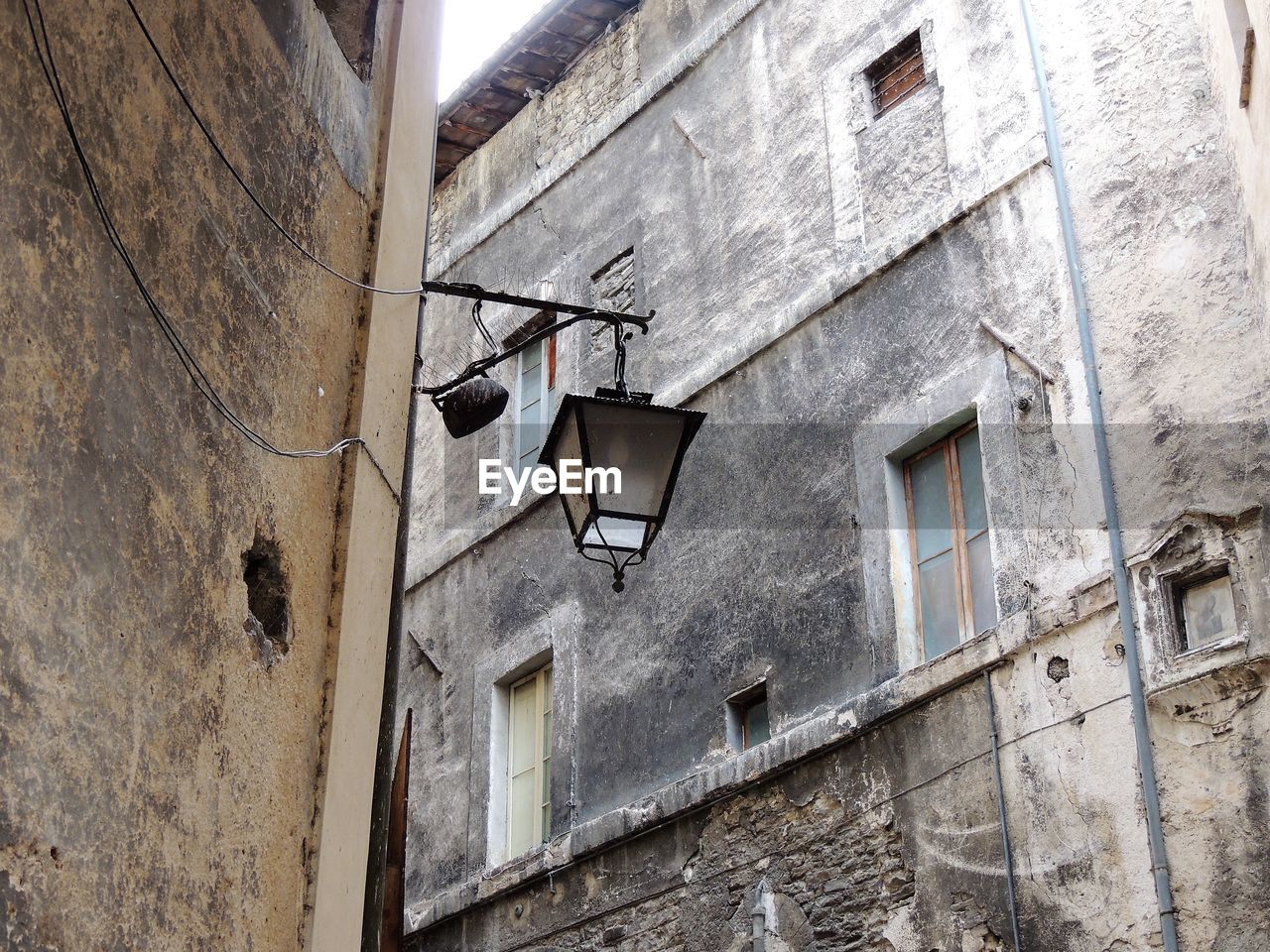 architecture, wall, building exterior, built structure, low angle view, window, building, no people, wall - building feature, urban area, road, street, alley, old, facade, house, day, residential district, lighting equipment, town, outdoors, city, weathered