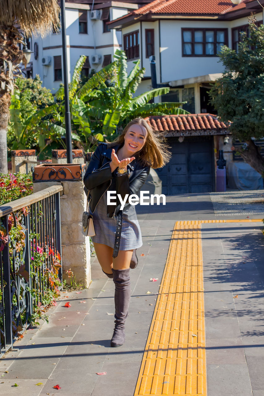 Portrait of happy woman standing on street