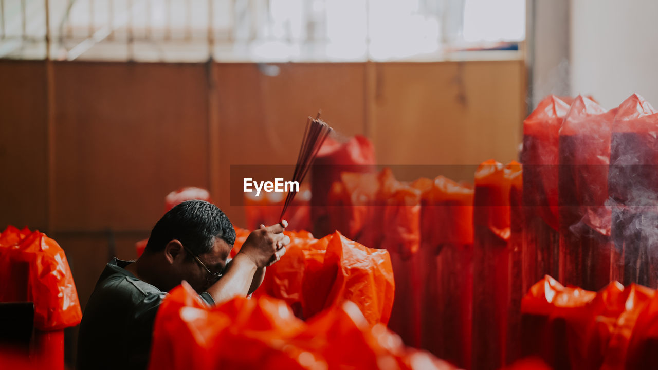 Man holding incense at temple