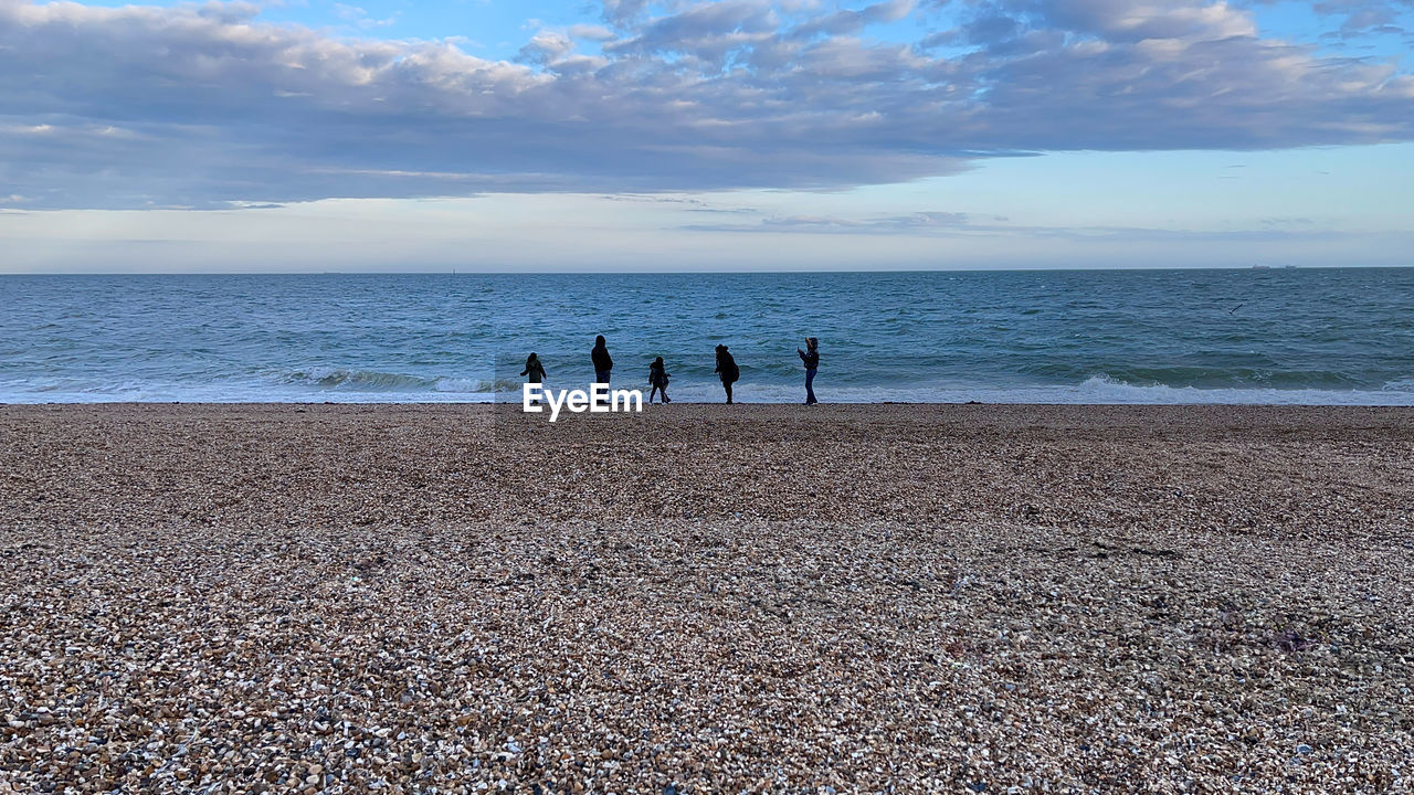 People on beach against sky