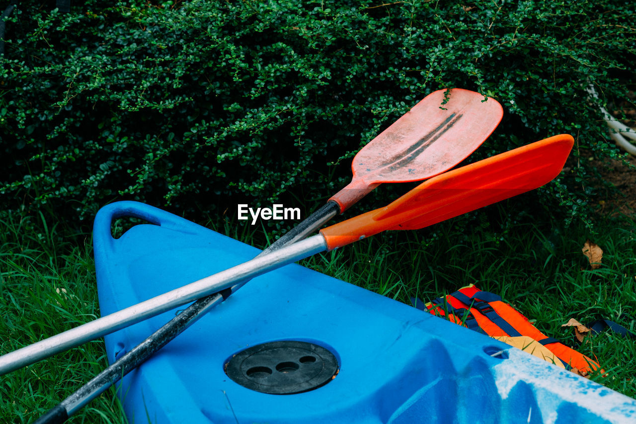 High angle view of kayak and oars on field