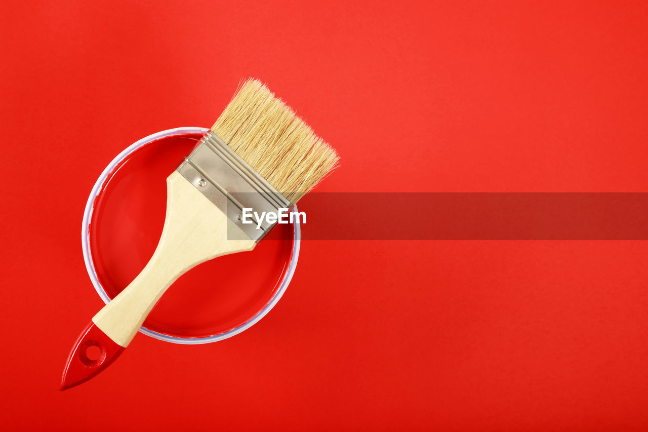 HIGH ANGLE VIEW OF PAINTBRUSHES AND RED BACKGROUND