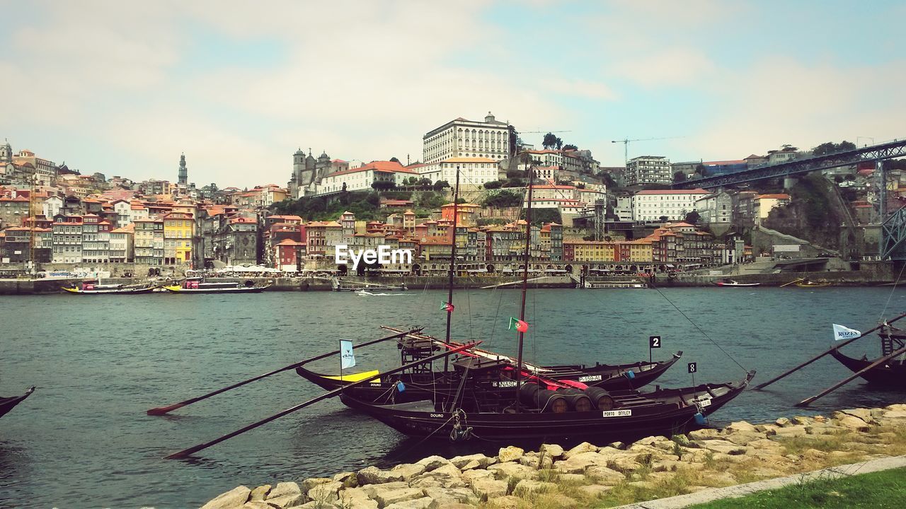 Moored boats on river in city