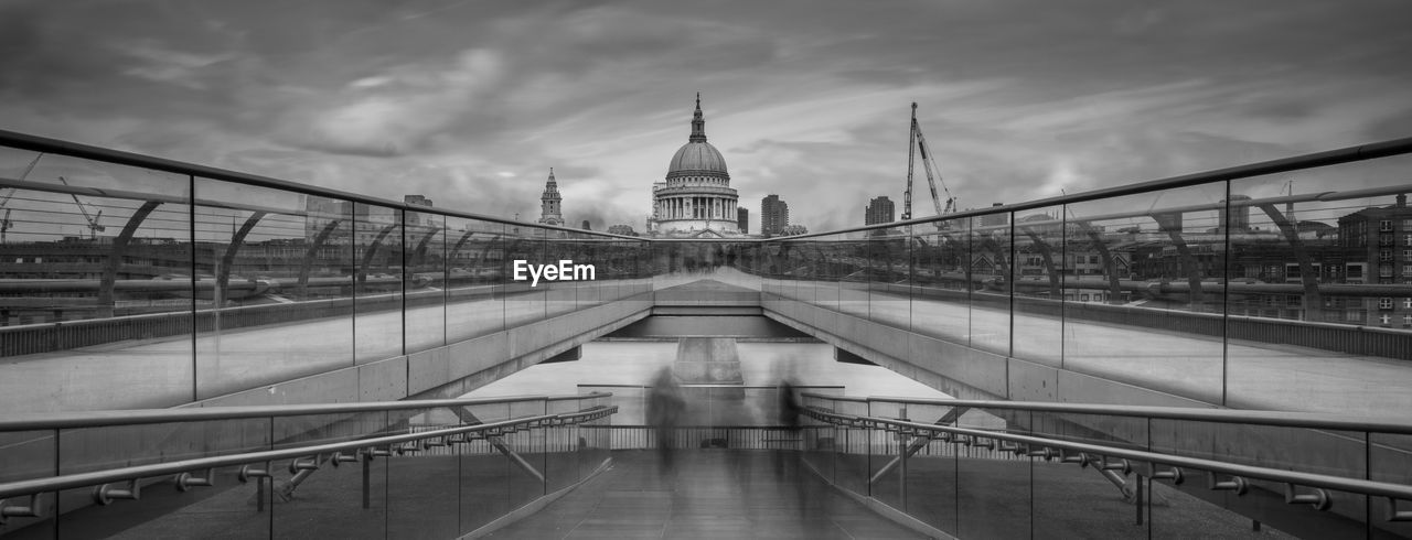 View of bridge in city against cloudy sky