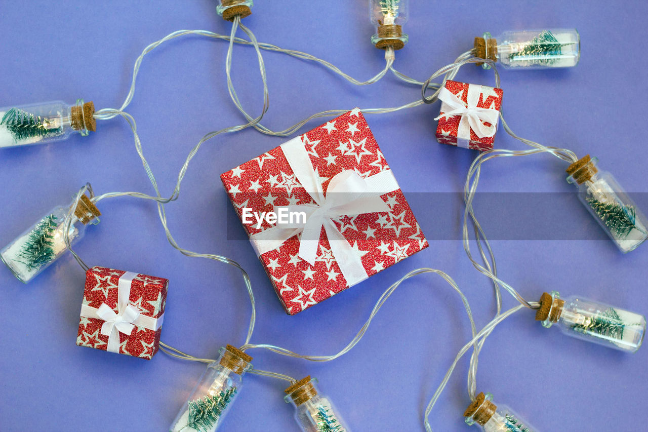 colored background, indoors, high angle view, studio shot, blue, no people, bead, gift, blue background, thread, earring, arts culture and entertainment, textile, still life, art, craft, directly above, creativity, jewellery, fashion accessory