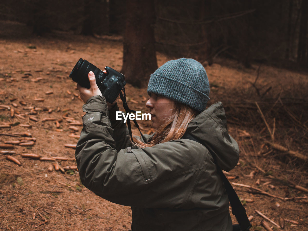 MIDSECTION OF MAN PHOTOGRAPHING IN FIELD