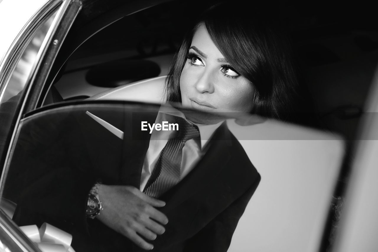 Portrait of woman looking through car window