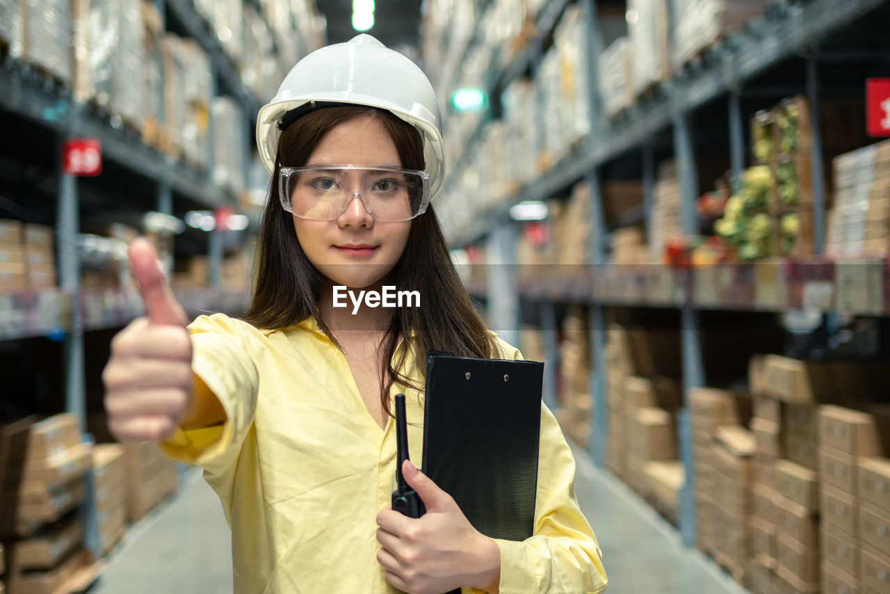 Female warehouse worker inspecting a warehouse in a factory. 