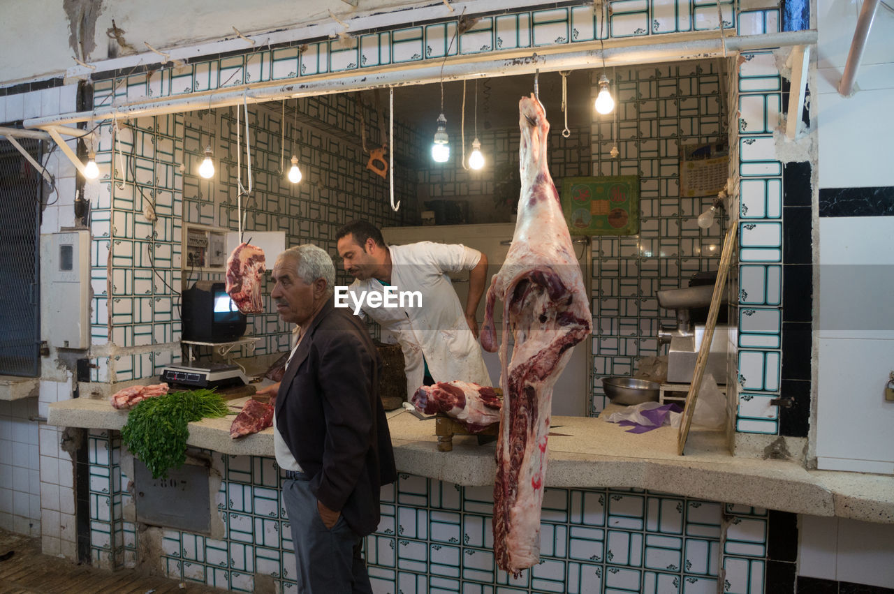 Customer standing by butcher at shop
