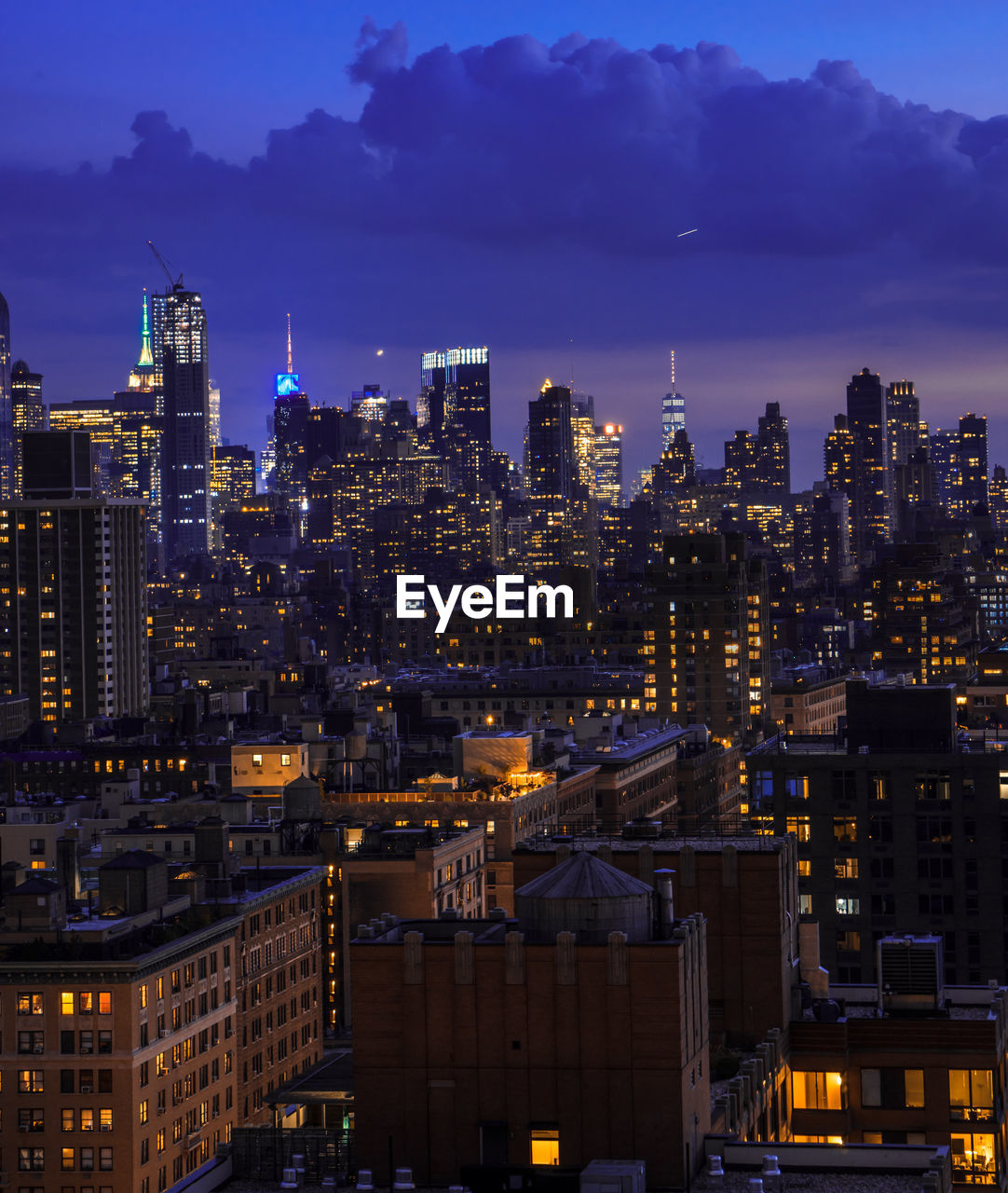 Illuminated cityscape against sky at night