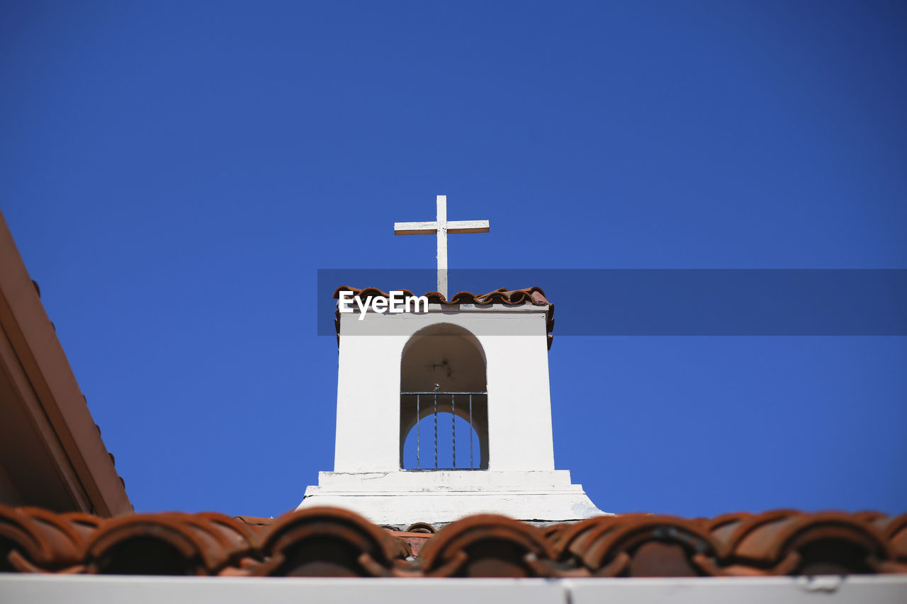 High section of cross against clear blue sky