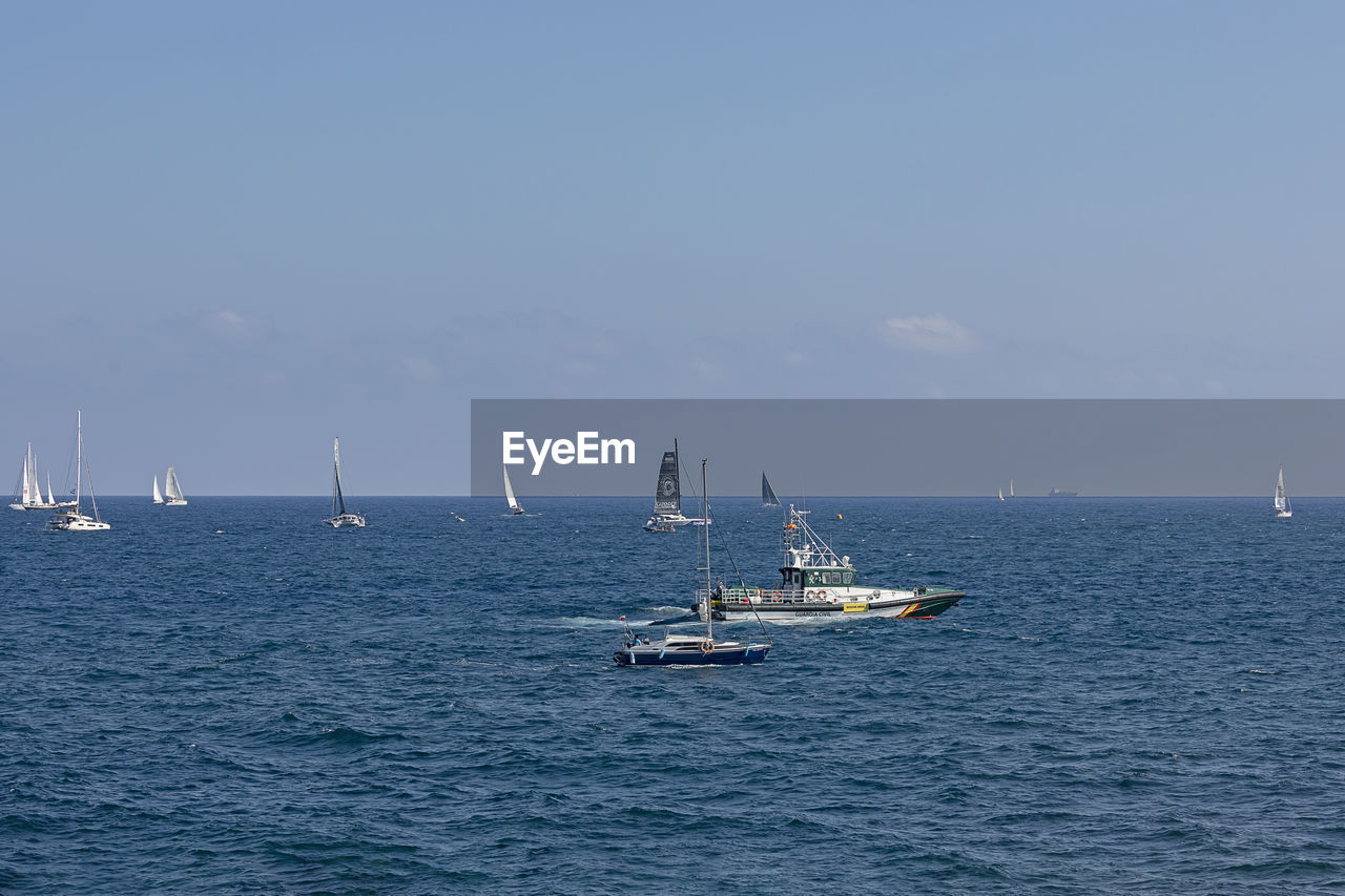 SAILBOAT SAILING IN SEA AGAINST SKY