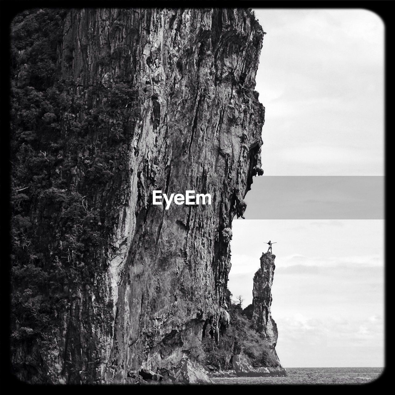 Woman standing on rock by the sea