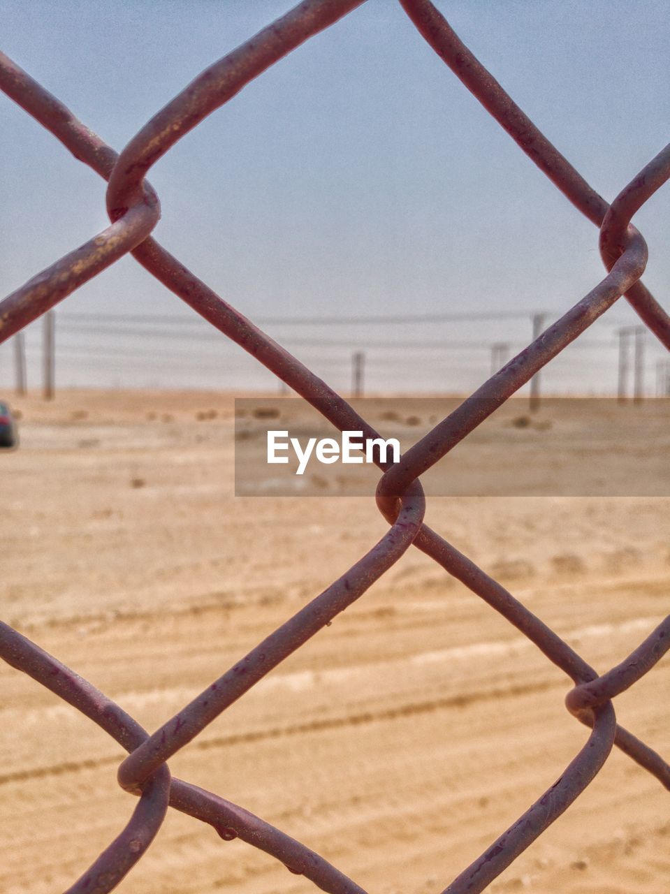 CLOSE-UP OF FENCE AGAINST SKY SEEN THROUGH CHAINLINK