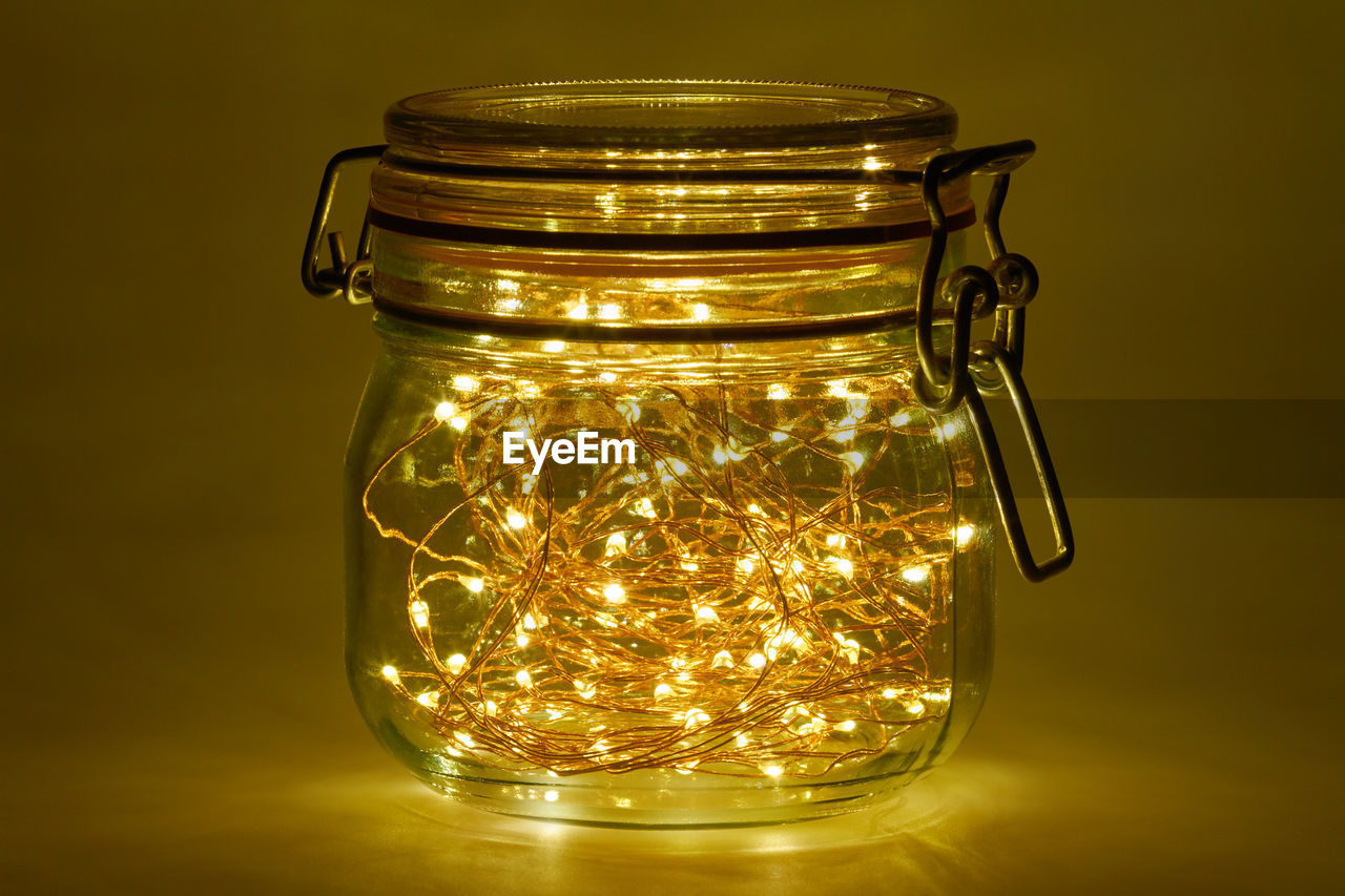 Close-up of illuminated string lights in jar on table