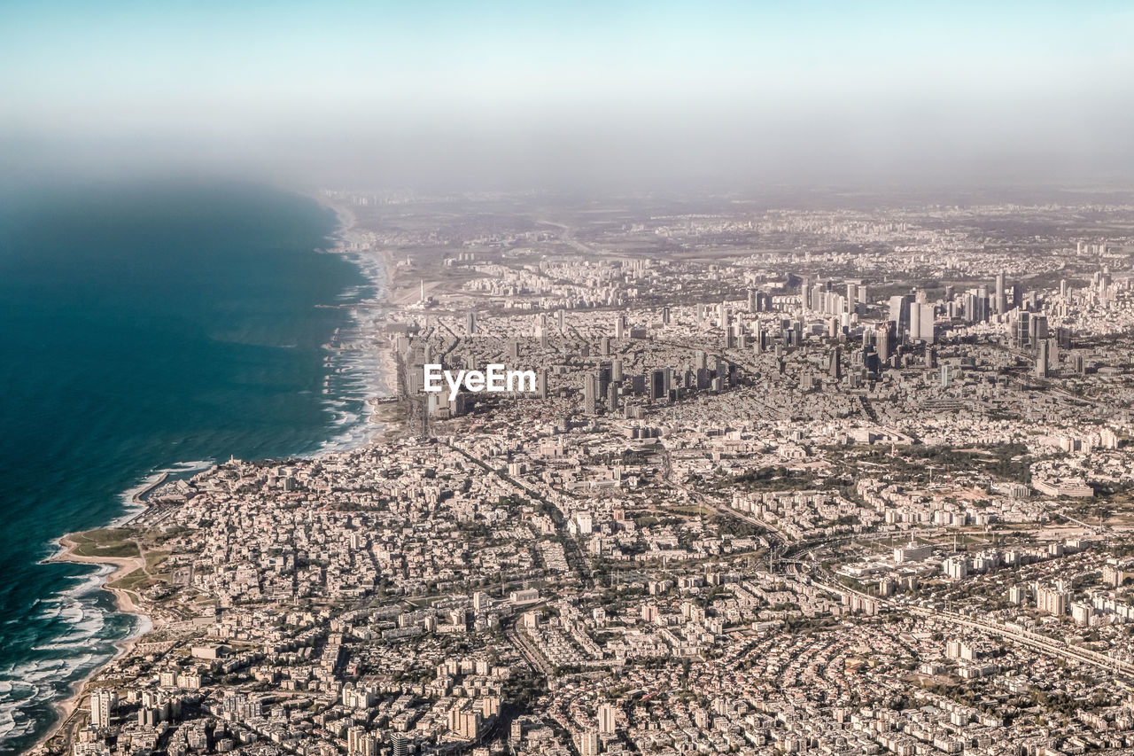 High angle view of tel aviv cityscape by sea against sky