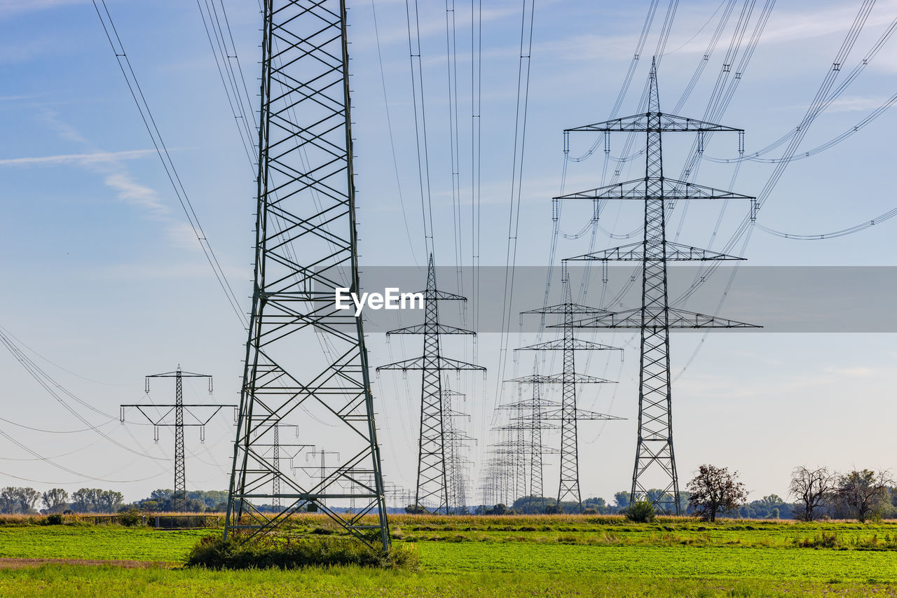 electricity pylons against sky