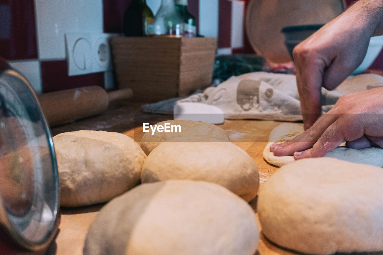 bread, food and drink, food, store, occupation, hand, freshness, bakery, one person, working, adult, baking bread, baked, baker, indoors, business, craft, dough, small business, skill, men, selective focus, close-up, loaf of bread, business finance and industry, holding, making, craftsperson, retail