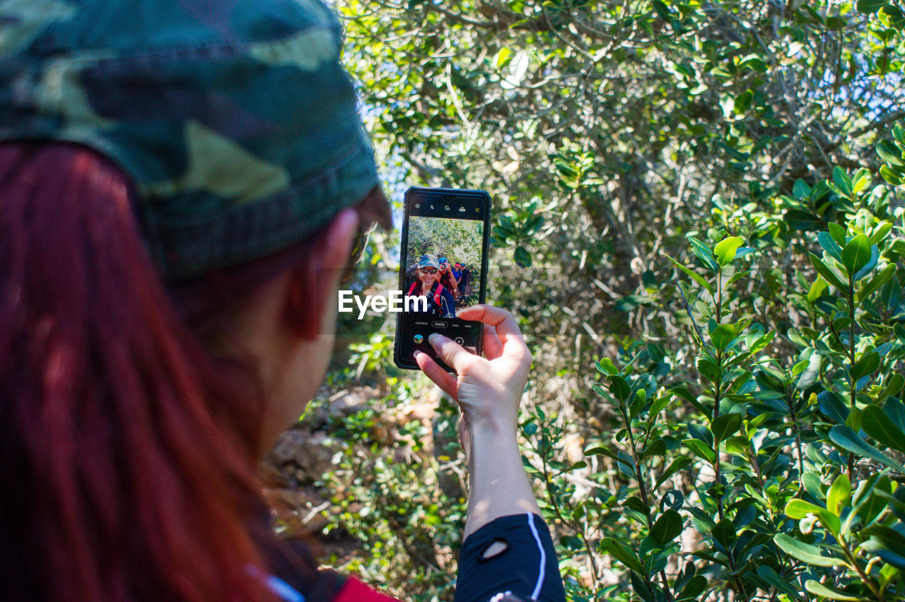 Portrait of woman photographing through mobile phone