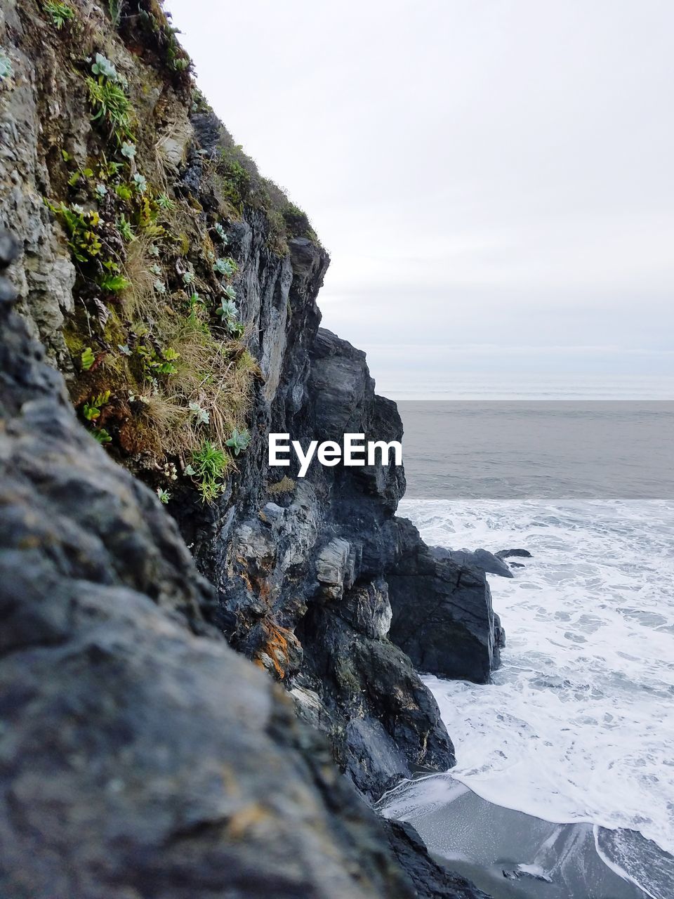 ROCKS IN SEA AGAINST SKY